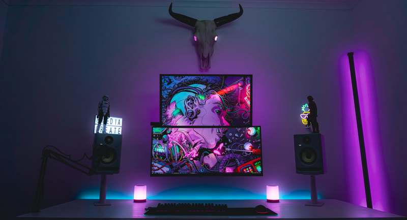 Overhead shot of vibrant gaming snacks on a dark desk beside a glowing RGB mechanical keyboard and headset